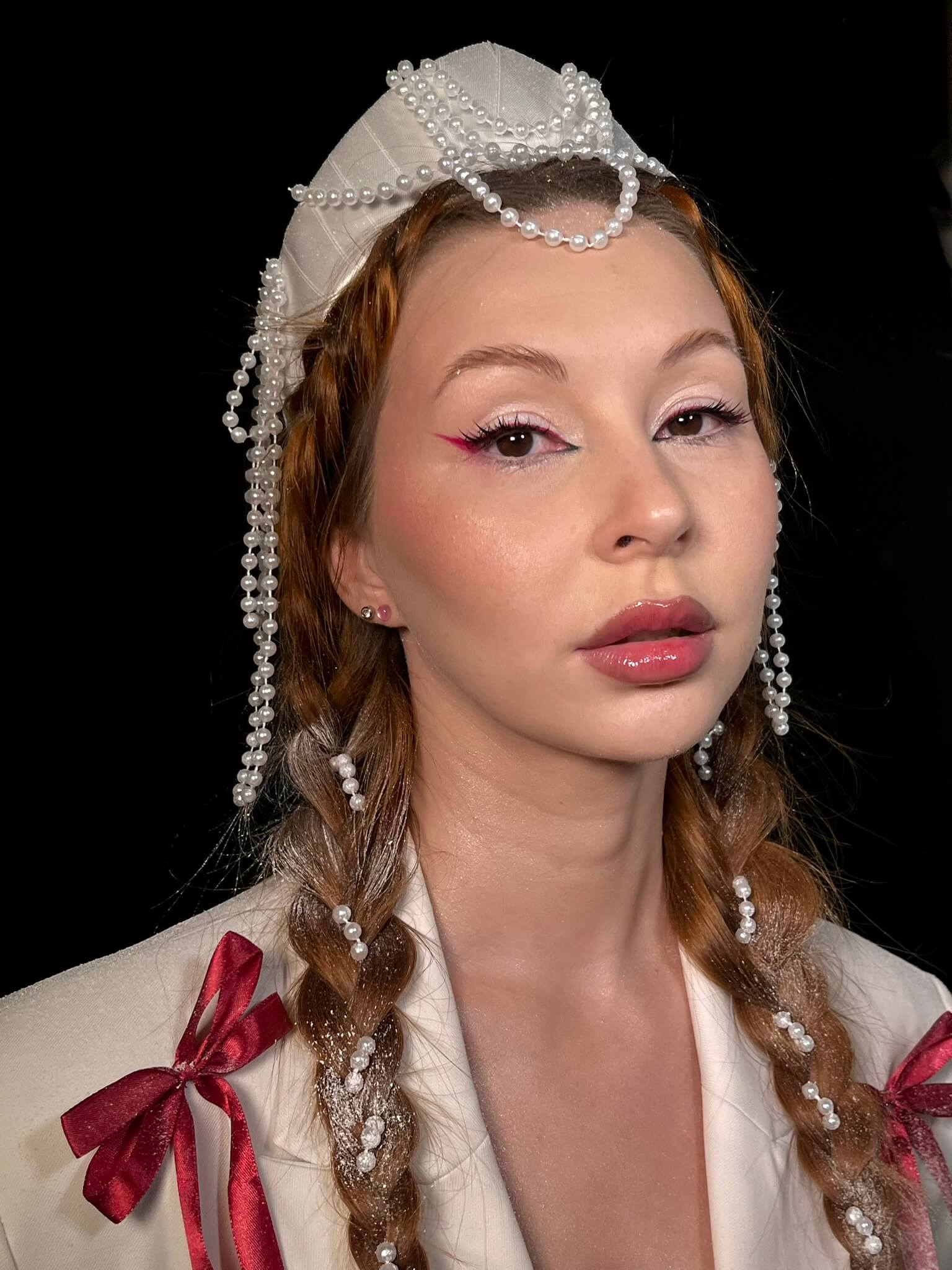Графичная розово-красная стрелка и сочные глянцевые губы, жемчужный убор с косами